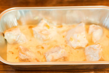 Creamy chicken fillet with nuts in bowl close