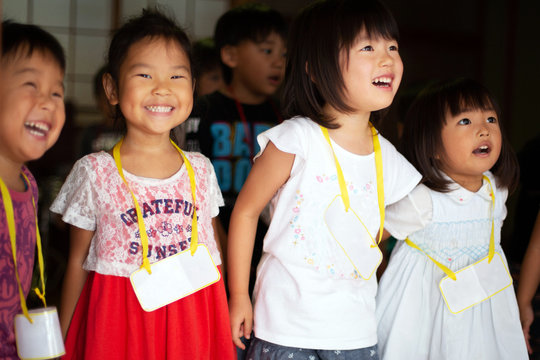 Group of girls and boys wearing name tags singing together in a temple. 