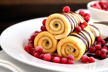 Homemade pancakes twisted with chocolate on a white plate.