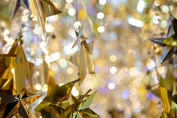 Golden star christmas background. Shiny glittering stars hanging on magical blurred bokeh background.