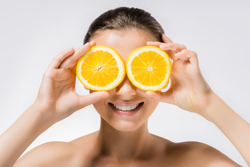 young smiling woman with orange slices on eyes