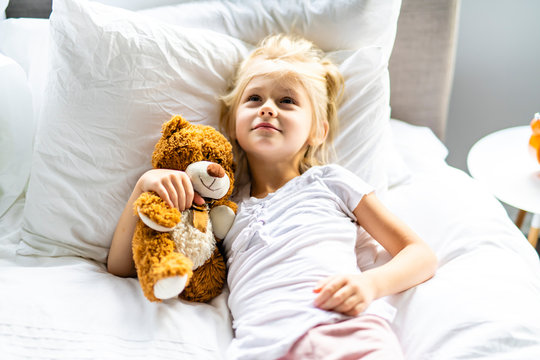 A Cheerful little girl in bed relax