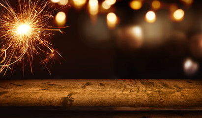 Christmas background with wooden table and sparkler