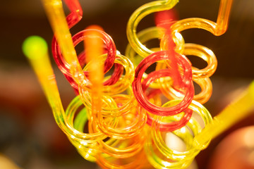 Color tubes for drinking juices. Curved in the form of a spiral. Blurred bright background...