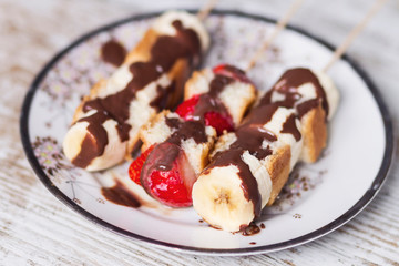 Fruit and cake skewers with melted chocolate