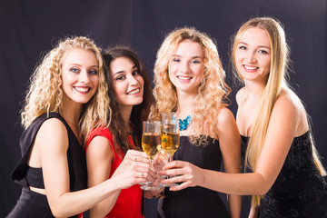 Party, holidays, celebration and new year eve concept - Cheerful young woman clinking glasses of champagne at the party
