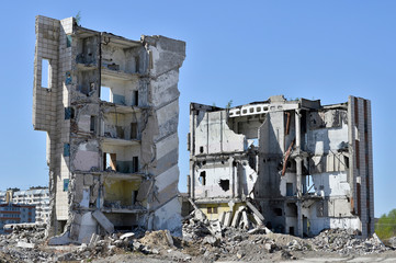 A pile of concrete debris on the background of a large destroyed building. Background.