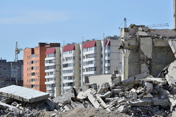 The remains of the concrete structure of the building against the residential part. Concept: destruction and creation