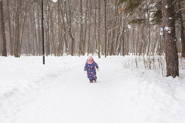 Children and nature concept - Adorable baby girl walking in winter park
