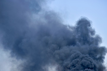 Powerful clouds of black smoke against the sky. Background. The problem of waste disposal