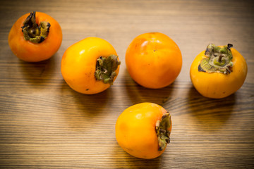 ripe exotic orange persimmon on wooden background