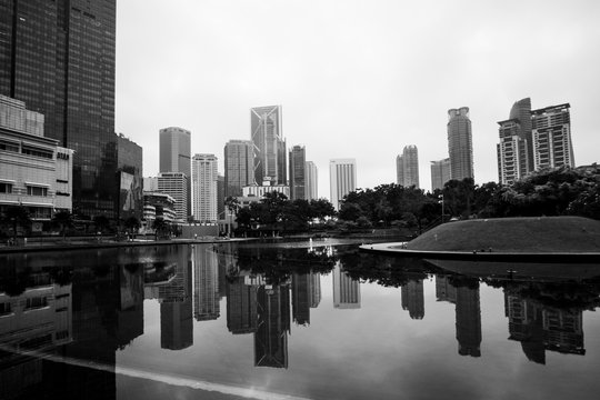 black and white image of building at Kuala Lumpur with reflection. soft focus,blur due long exposure. visible noise due to High ISO.