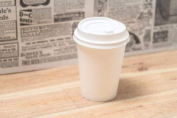 Cup of coffee to go on the wooden table with latte art. Street coffee.