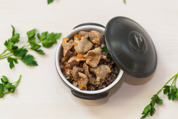 stewed chicken stomachs with vegetables and buckwheat in a bowl