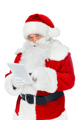 serious santa claus using digital tablet isolated on white