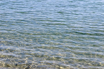 Crystal clear blue sea water sea surface texture background wallpaper detail fragment close up