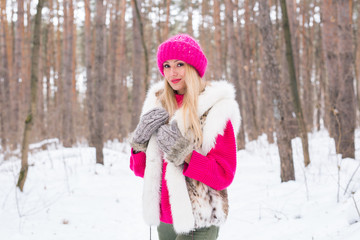 Fototapeta na wymiar Nature, fashion and people concept - Young attractive blond woman posing in the winter park.