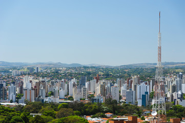 City landscape with buildings, houses, a large antenna tower and also green area with trees