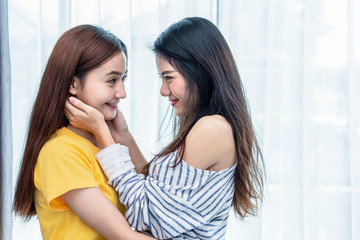 Two Asian women looking at each others in home. People and lifestyles concept.  LGBT pride and lesbian theme.