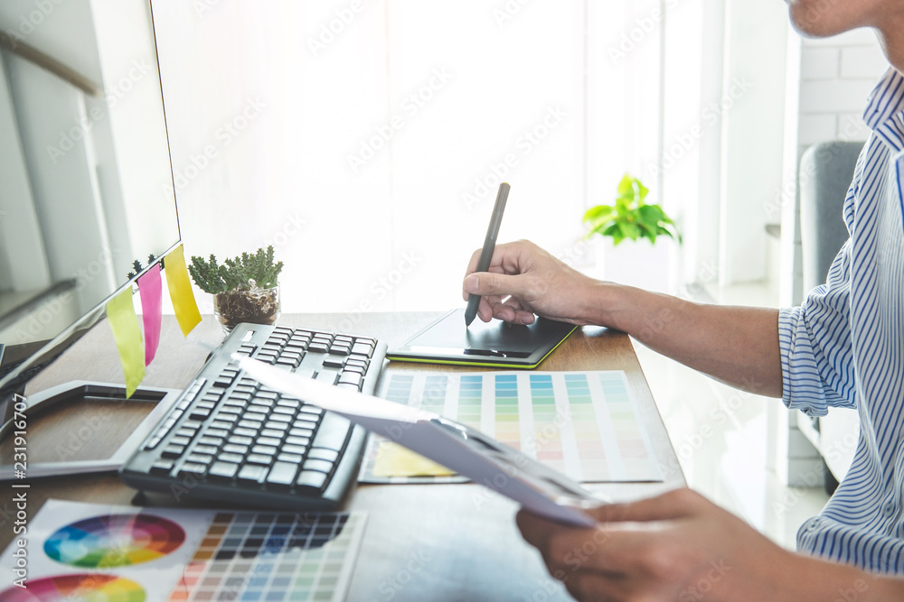 Aufkleber Image of male creative graphic designer working on color selection and drawing on graphics tablet at workplace with work tools and accessories in workspace