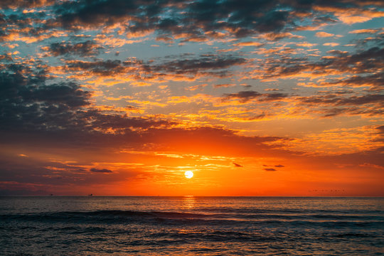 Fototapeta sea sunrise and beautiful cloudscape over the waves