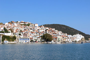 Skopelos town island greece mediterranean harbor port houses church hill sky cityscape coastline...