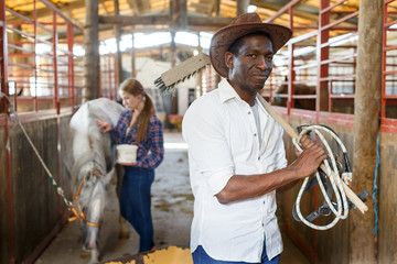 Fototapeta na wymiar Portrait afro man horse farm worker