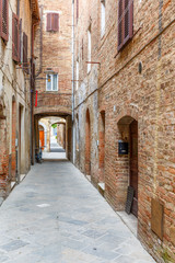 Fototapeta na wymiar Empty alley with old brick houses