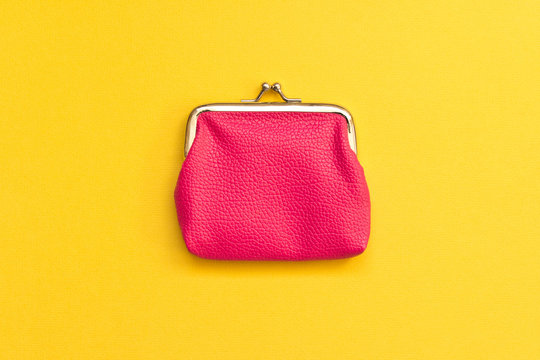 Pink wallet on yellow background . Close up. Top view