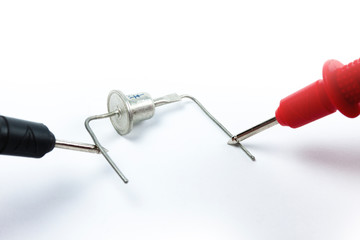 Testing diode bridge with multimeter on white background