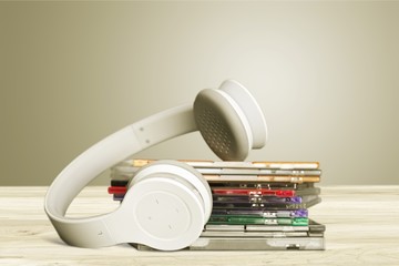 Headphones and compact discs  on wooden background