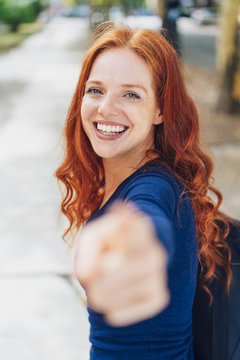 attractive redhead woman pointing at the camera