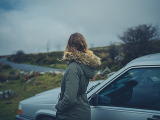Woman standing by her car on the moor