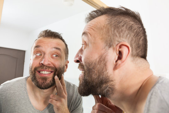 Man looking at beard in mirror