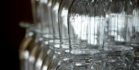 empty drinking glasses in a restaurant on black background, shallow dof image