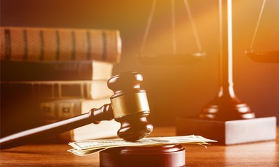 Justice Scales and books and wooden gavel with money on table