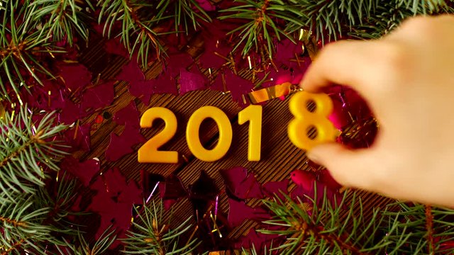 Christmas figures 2018 on a wooden background with sparkles and sparkler, hand replaces 2018 with 2019, replacement, new year, christmas, background