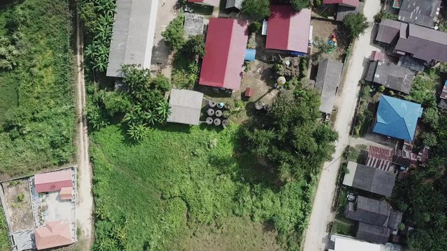 Aerial view of a rural school with red roofs and soccer field in Thailand