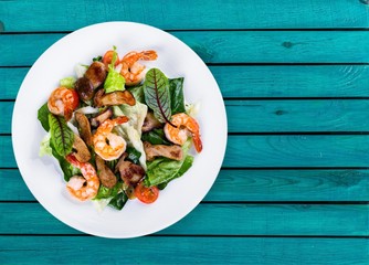 Green salad with shrimps on background