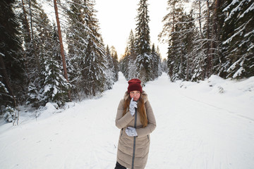 Fototapeta na wymiar Young woman standing at the crossroads of snow covered winter pine forest. Concept of choice of paths