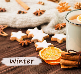 Obraz na płótnie Canvas Winter theme. Cup of hot tea with spices, orange, cinnamon, anis