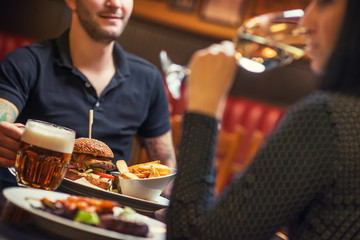 people eating and drinking in american restaurant, beer, hamburger, wine and other american specialites