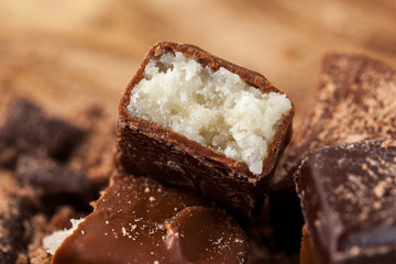 Various yummy chocolate candies on wooden table, sweets