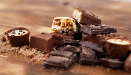 Various yummy chocolate candies on wooden table, sweets
