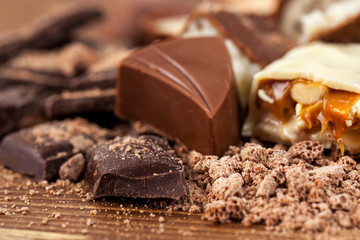 Various yummy chocolate candies on wooden table, sweets