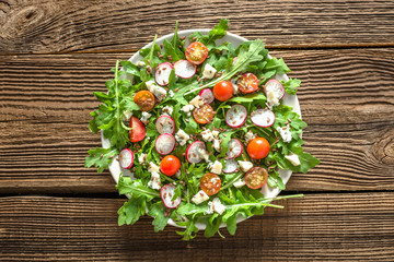 Appetizing vegetable salad, fresh food on plate on wooden background, healthy nutrition concept