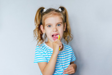 Fototapeta premium children's dental hygiene. child brushes his teeth with a toothbrush. health care, dental hygiene, people and beauty concept. mockup, free spase. selective focus. 
