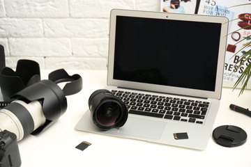 Laptop and professional photographer's equipment on table indoors. Space for text