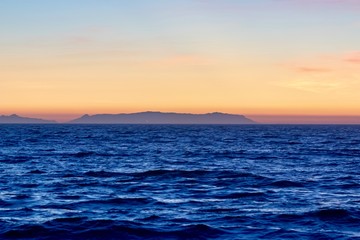 colorful sunset sky over an island and ocean