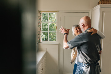 Senior couple dancing at home - Powered by Adobe